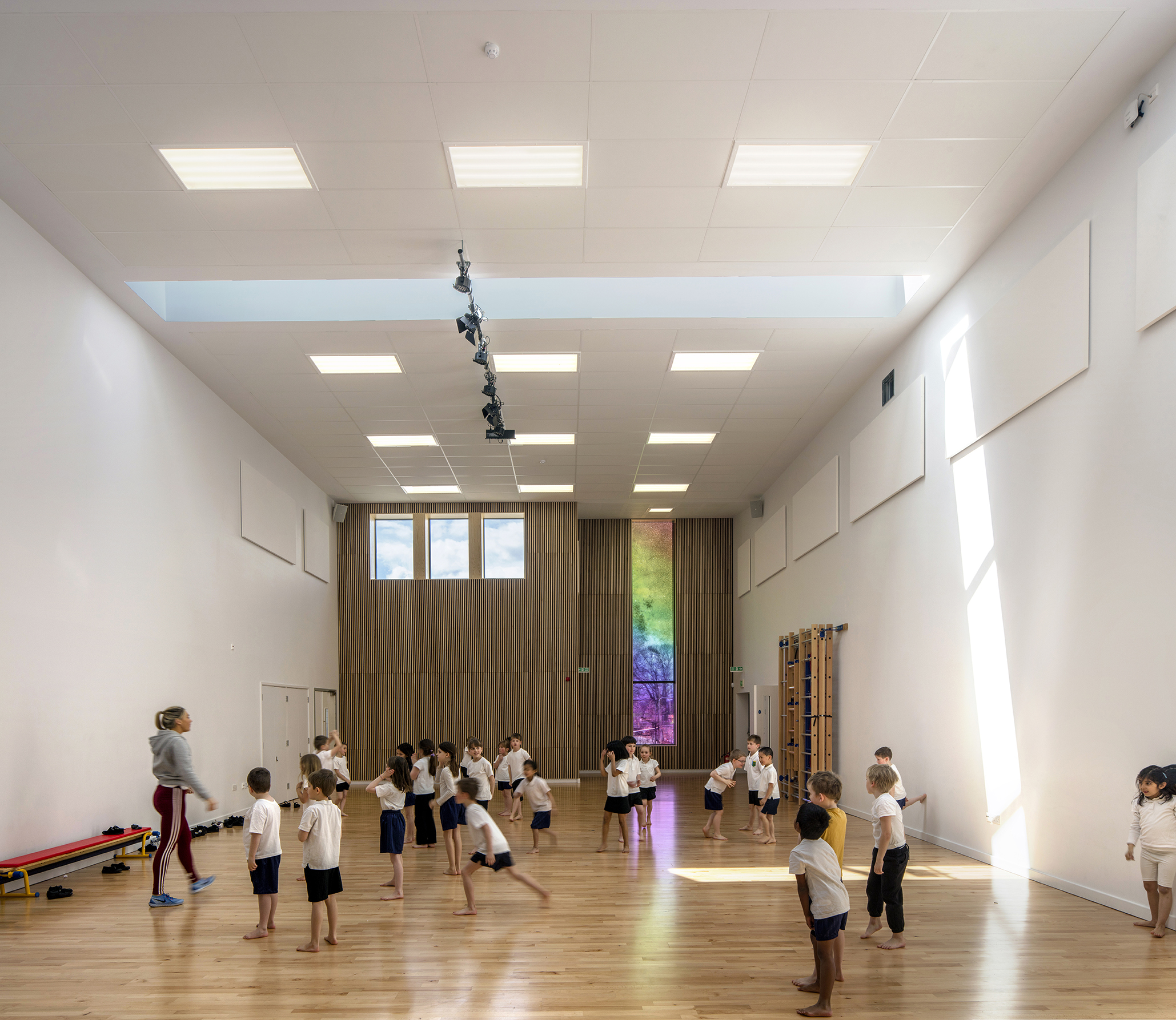 kids exercising indoors - University of Cambridge Primary School by Marks Barfield Architects